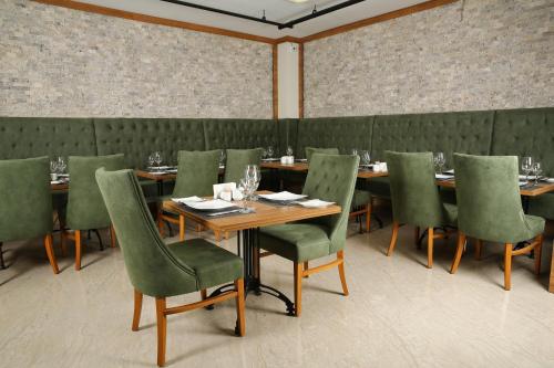 a dining room with wooden tables and green chairs at Golden Lounge Hotel in Istanbul