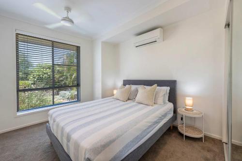 a bedroom with a large bed and a window at 20 Taine - Oceanstays - Jetty & Pet Friendly in Yamba