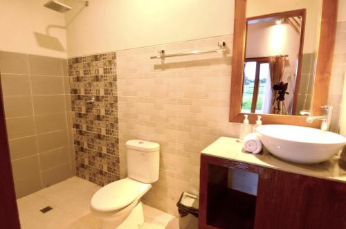 a bathroom with a toilet and a sink and a mirror at Ubud 3-bedrooms with sunset view in Ubud