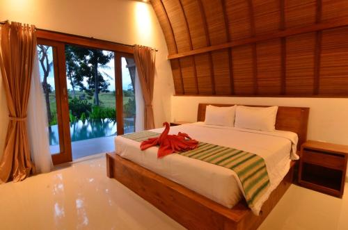 a bedroom with a bed and a large window at Ubud 3-bedrooms with sunset view in Ubud
