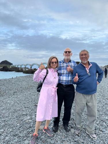 a group of three people standing on a rocky beach at B&G Crafs Art House in Chenggong