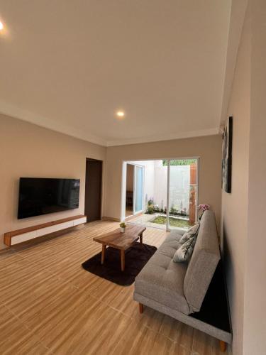 a living room with a couch and a flat screen tv at Tera Bali Villa Bedugul in Buleleng