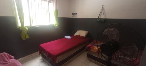 アナニンデウアにあるResidencial New Ville 2のベッドルーム1室(赤いベッド1台、ファン付)