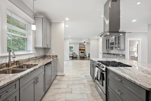a kitchen with a sink and a stove top oven at The Ultimate Luxury Home with Jacuzzi & Garage in Falls Church