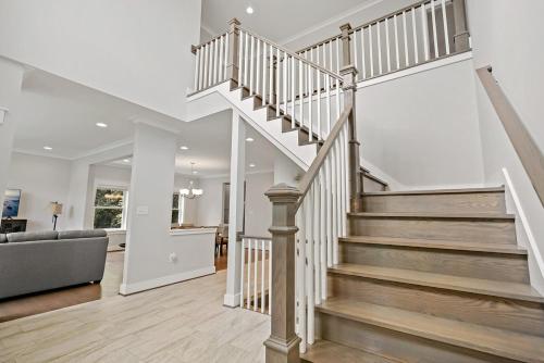 a staircase in a home with white walls and wood floors at The Ultimate Luxury Home with Jacuzzi & Garage in Falls Church