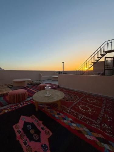 a living room with a table and a view of the ocean at Playa Surf House in Tamraght Ouzdar
