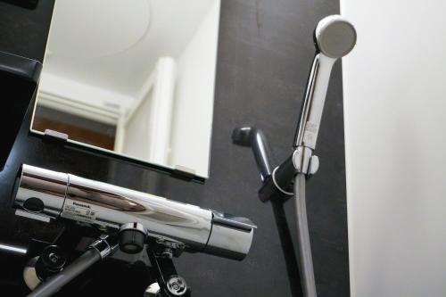 a hair dryer and a mirror in a bathroom at Purpure Furano in Kami-furano