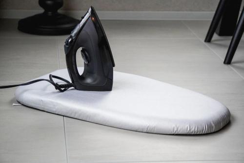 a black iron sitting on top of a white pillow at Purpure Furano in Kami-furano