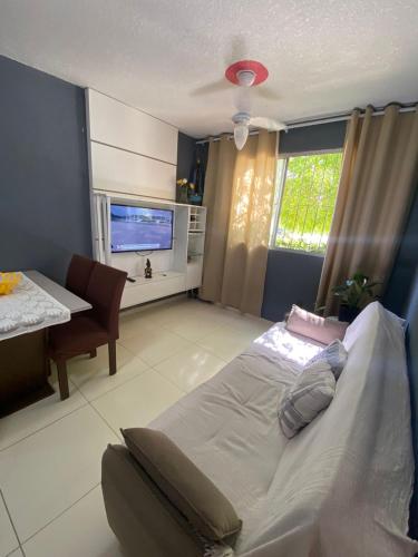 a bedroom with a large bed and a television at Apartamento da Letícia in Camaçari