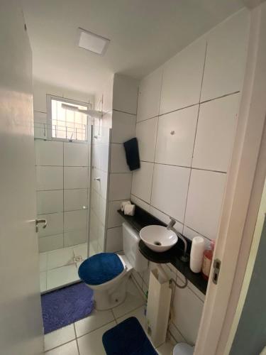a bathroom with a toilet and a sink and a shower at Apartamento da Letícia in Camaçari