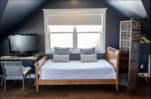 a bedroom with a bed and a tv and a window at Lekai Ranch Forever Vineyard Views in Paso Robles