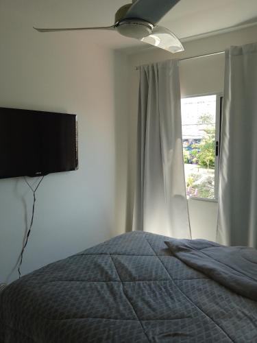a bedroom with a bed and a flat screen tv at Ap no centro do Vila Branca in Jacareí
