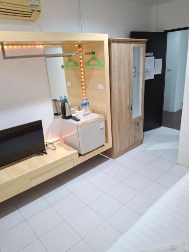 a room with a desk with a television and a counter at Urban Patong Residence in Patong Beach