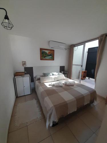 a bedroom with a bed with a plaid blanket at Los Paraísos Oro Verde in Oro Verde