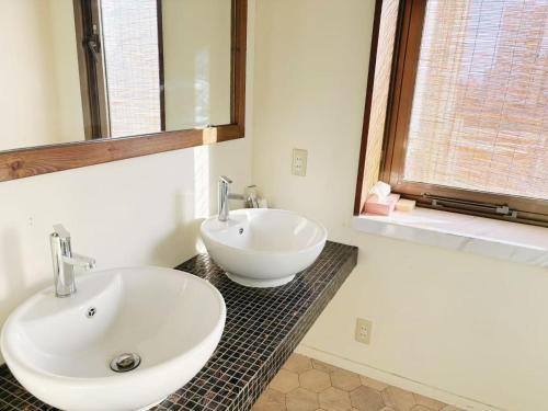 a bathroom with a white sink and a bath tub at 颯House 4 in Osaka