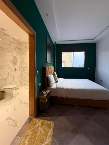 a bedroom with a large bed and a bathroom at Playa Surf House in Tamraght Ouzdar