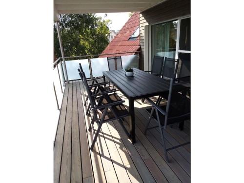 a wooden table and chairs on a deck at Oak Comfortable Holiday Residence in Leutkirch im Allgäu
