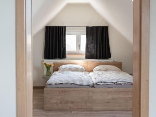 a bedroom with a bed with black curtains and a window at Oak Comfortable Holiday Residence in Leutkirch im Allgäu