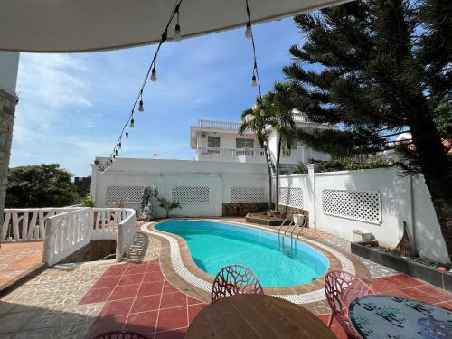 头顿Trần Phú Homestay Vũng Tàu - View biển bãi trước - 7 phòng ngủ lớn - Hồ bơi riêng的一个带桌椅的庭院内的游泳池