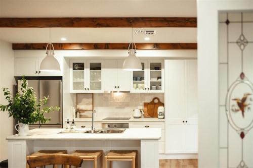 una cucina con armadi bianchi e un'isola cucina di Kookaburra Cottage - 10 minutes from Mount Gambier CBD a Yahl Paddock