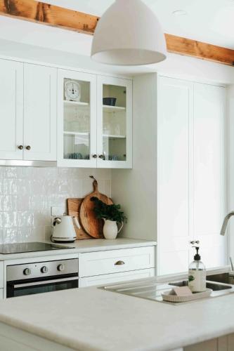 a kitchen with white cabinets and a white counter top at Kookaburra Cottage - 10 minutes from Mount Gambier CBD in Yahl