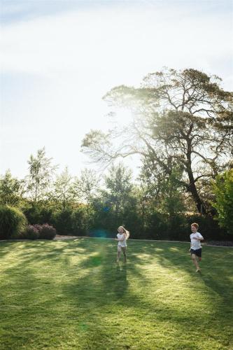 two children playing frisbee in a grassy field at Kookaburra Cottage - 10 minutes from Mount Gambier CBD in Yahl Paddock