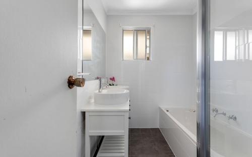 a white bathroom with a sink and a bath tub at Seaside Escape - 4 Brittain St, Port Elliot in Port Elliot