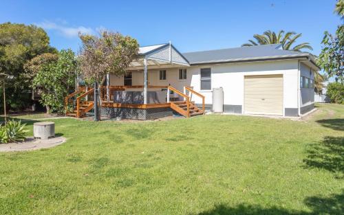 a house with a deck and a yard at Seaside Escape - 4 Brittain St, Port Elliot in Port Elliot