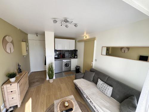 un salon avec un canapé et une cuisine dans l'établissement Charmant 2 pièces à 2 pas de la plage avec loggia - tout confort - FR-1-712-9, à Villers-sur-Mer