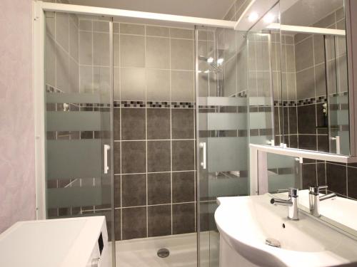 łazienka z prysznicem, umywalką i lustrem w obiekcie F3 avec Wifi à 150m du centre et thermes du Mont-Dore - 5 couchages - FR-1-415-143 w mieście Mont-Dore