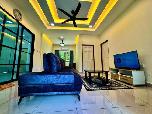 a living room with a blue couch and a ceiling at Vinzsugudhomestay in Bundo