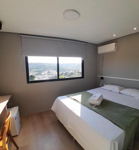 a bedroom with a large bed with a large window at Zuppolini Garden Hotel in Bananeiras
