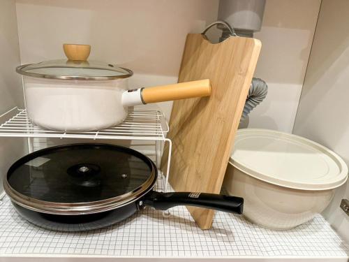 a pan sitting on a rack next to a pot at 大阪一軒家 最大8名 WiFi 粉浜駅8分 関西空港直通 天下茶屋電車2分 in Osaka