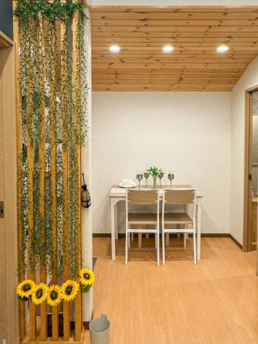 a dining room with a table with sunflowers at 大阪一軒家 最大8名 WiFi 粉浜駅8分 関西空港直通 天下茶屋電車2分 in Osaka