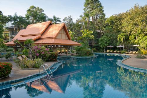 a swimming pool at a resort with a building at The Green Park Resort in North Pattaya