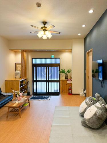 a living room with a couch and a ceiling fan at 大阪一軒家 最大8名 WiFi 粉浜駅8分 関西空港直通 天下茶屋電車2分 in Osaka