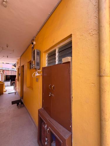 a building with a yellow wall with a window at Mahesh Guest House in Hampi