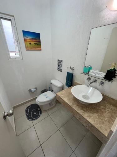 ein Badezimmer mit Waschbecken, Toilette und Spiegel in der Unterkunft Departamento Blue Vacacional in Playa del Carmen