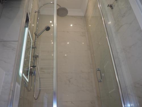 een badkamer met een douche met een glazen deur bij Grand-Tourist Old Town Center Apartments in Gdańsk