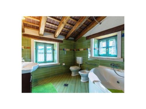 a bathroom with a tub and a sink and a toilet at Villa Maccaroni Comfortable holiday residence in Paz