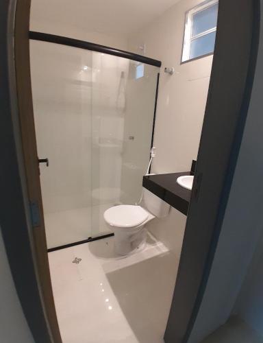 a bathroom with a toilet and a sink at Zuppolini Garden Hotel in Bananeiras