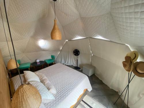 a bedroom with a white bed in a tent at Tinku Huasi Domos Suite in Tilcara