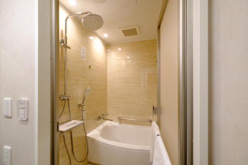 a bathroom with a white tub and a sink at ホテル　サンシャインとうはく in Yabase