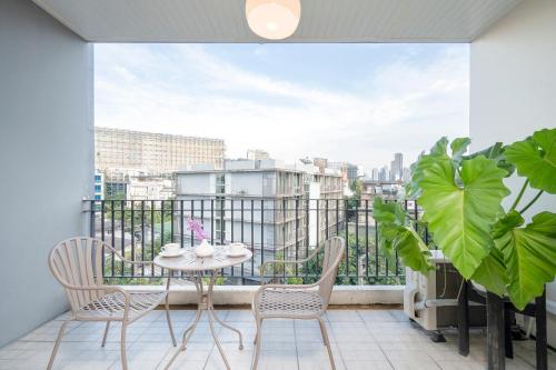 a balcony with a table and chairs and a view at Hotel De Bangkok in Bangkok