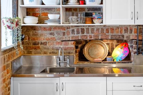 a kitchen with a sink and a plate in a shelf at Secret River Cottage in Windsor