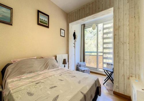 une chambre avec un grand lit et une fenêtre dans l'établissement Square Victoria, à Menton