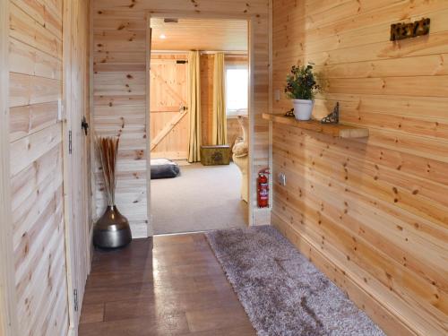 a hallway with wood paneled walls and a doorway at Algwen Cabin in West Walton