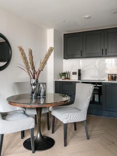 a kitchen with a dining room table and chairs at The Spitalfields Works by Urban Rest in London