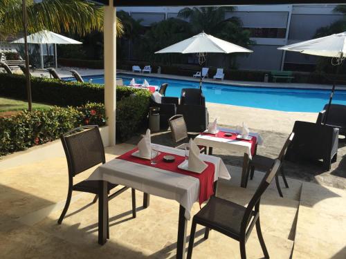 a group of tables and chairs next to a pool at Savoy Hotel Boutique in Las Terrenas