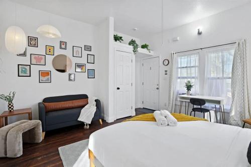 a white bedroom with a bed and a couch at Cozy Upstairs Studio Near Downtown and the River in Sacramento